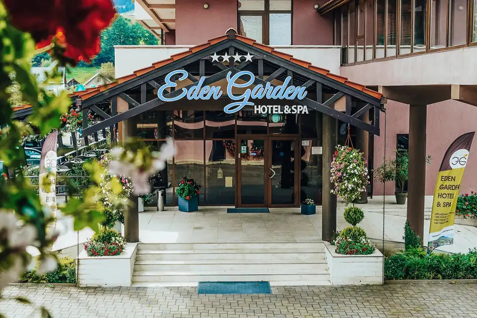 Intrarea principală în Hotel Eden Garden & Spa, cu trepte și copertină din lemn