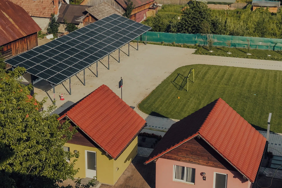 Vedere aeriană spre bungalowuri, teren de sport și structură cu panouri solare în complexul Eden