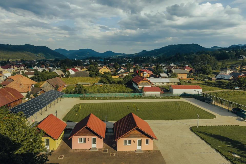 Bungalowuri și curtea complexului Eden, cu orașul și dealurile în fundal