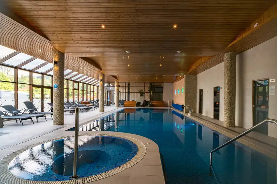 Piscină interioară și bazin circular, cu șezlonguri lângă ferestre, la Hotel Eden Garden & Spa